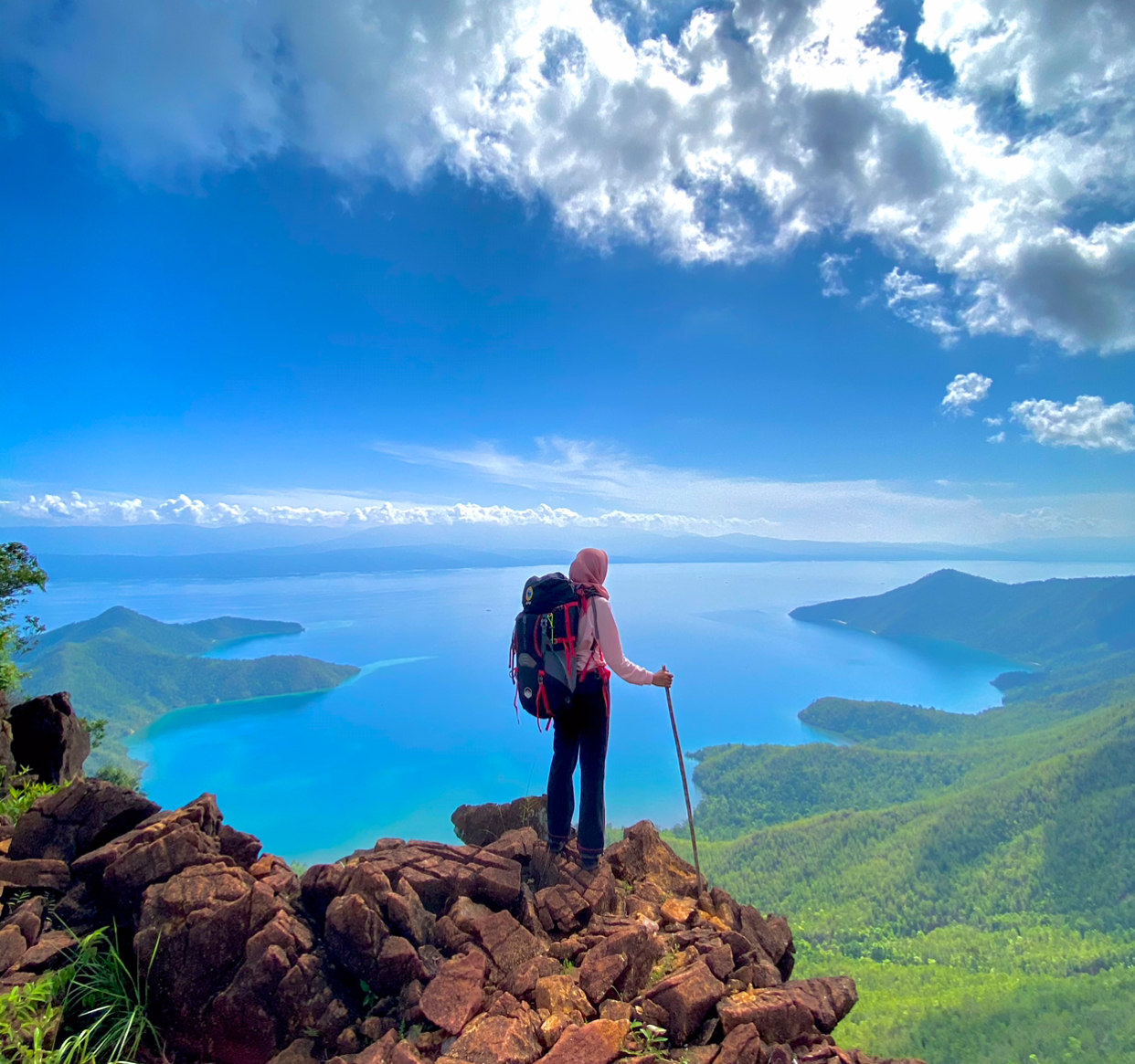 Seorang pengunjung sedang berada tepat di puncak Pulau Padamarang sembari menikmati keindahan alamnya. Foto: Bella.